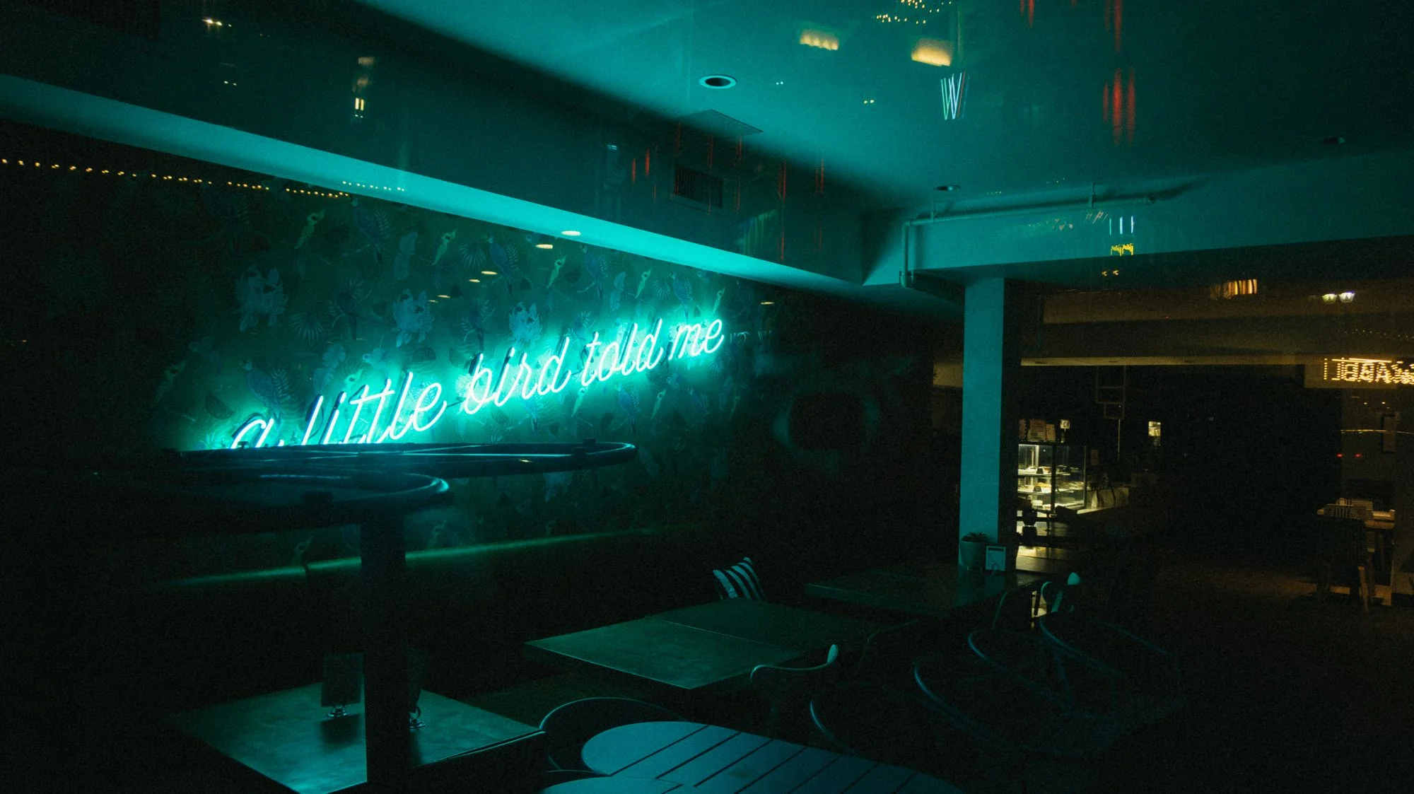 Pime restoranisaal, mida valgustab neoonsilt